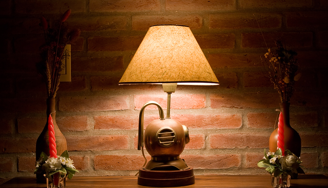 Lámpara sobre una mesa, pared de ladrillos de fondo
